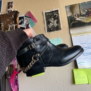 STEVE MADDEN black leather ankle booties with a gold chain and buckles.